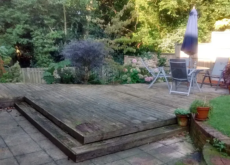 Weathered grey garden decking before pressure washing