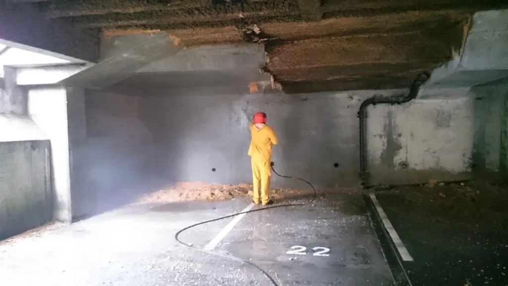 Industrial cleaning in Guildford, fire retardant foam being stripped from the ceiling of an underground car park with a pressure washer